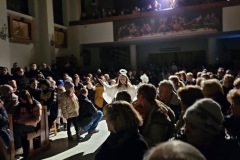 Taniec aniołów podczas przedstawienia. Zdjęcie prezentuje wnętrze kościoła przy wygaszonym świetle.