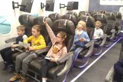 Uczniowie klasy 1c siedzą w symulatorze samolotu