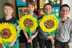 Uczniowie klasy 1b prezentujący przygotowane przez siebie kwiaty