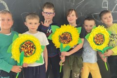 Uczniowie klasy 1f prezentujący przygotowane przez siebie kwiaty