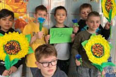 Uczniowie klasy 3e prezentujący przygotowane przez siebie kwiaty