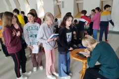Pani  Ewa Rosolska składająca autograf wśród licznej grupy czekających uczniów