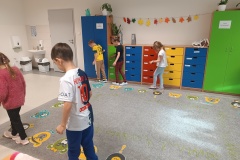 Uczniowie mierzą długość dywanu za pomocą stóp