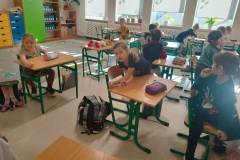 Uczniowie za pomocą łokci mierzą długość swojej ławki