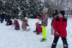 Uczniowie w trakcie zabawy, rzucanie śnieżkami do celu