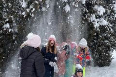 Uczennice w trakcie zabawy śniegiem, zsypujące śnieg z drzew
