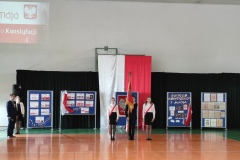 Poczet sztandarowy stojący na środku sali gimnastycznej