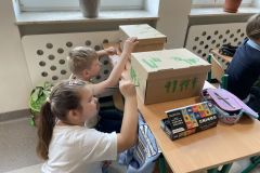Chłopiec i dziewczynka podczas malowania pudełek farbami.