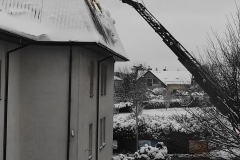 Strażacy sciągający śnieg z dachu szkoły z wysięgnika strażackiego (3)