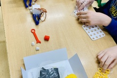 Uczniowie rozkładają elementy konstrukcyjne robota