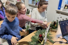 Uczniowie podczas wykonywania stroika świątecznego w towarzystwie instruktorki pani Beaty Godyni - Kapalki.
