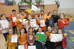 Uczniowie klasy 3b przezentują ciekawostki o warzywach i owocach w kolorze pomaranczowym.