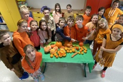 Uczniowie prezentują owoce i warzywa w kolorze pomarańczowym