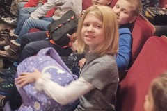 Uczniowie siedzący na widowni w teatrze